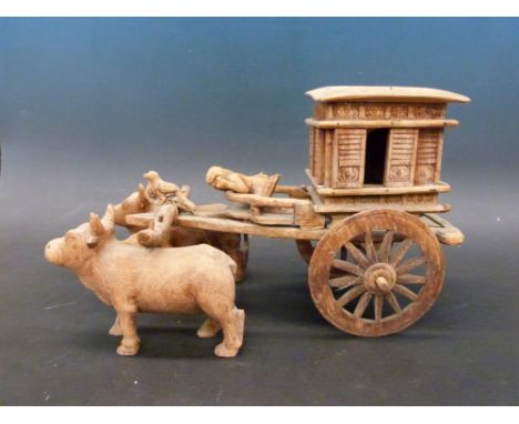 An Indian carved model of a oxen drawn carriage with lift off lid and working shutters 