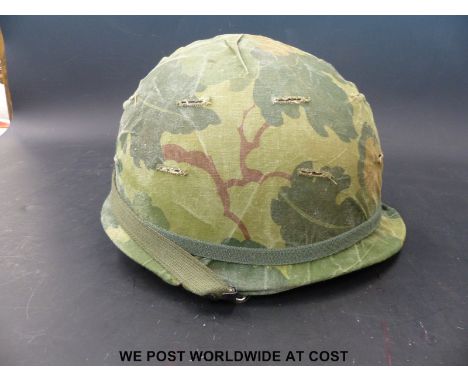 A US Army Vietnam era steel helmet with cover and inner, dated 1964