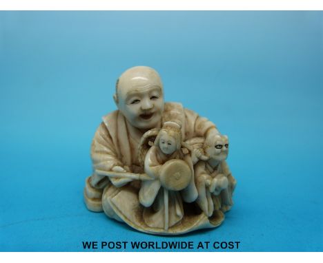 A signed Japanese Meiji period carved ivory netsuke of an artisan painting figures, perhaps a ceramic or okimono artist (4.5c