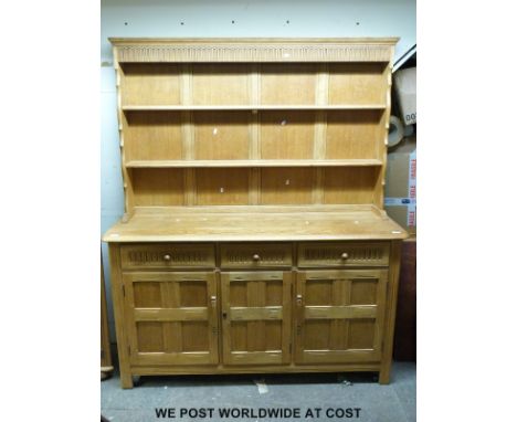 A light oak dresser in the Arts and Crafts style (H180  x W146 x D46cm)