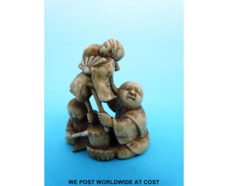 A Japanese Meiji period carved ivory netsuke of a puppeteer and a musician (4.2cm tall)