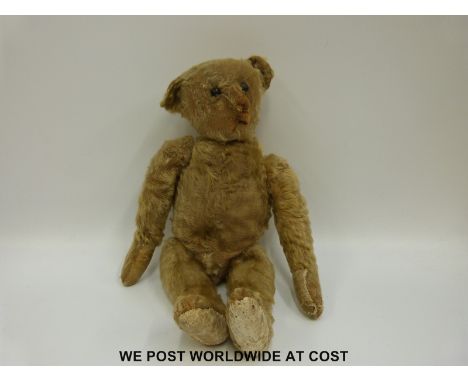 Steiff mohair bear with cocked feet and wrists, jointed limbs and pointed snout, with a photograph featuring it being held by