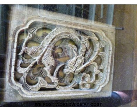 A carved Chinese hardwood panel depicting a dragon in a glazed box frame and a Chinese tapestry of children playing in a gard