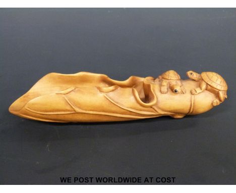 A cherry wood caddy spoon in the form of a folded leaf carved with two small tortoises
