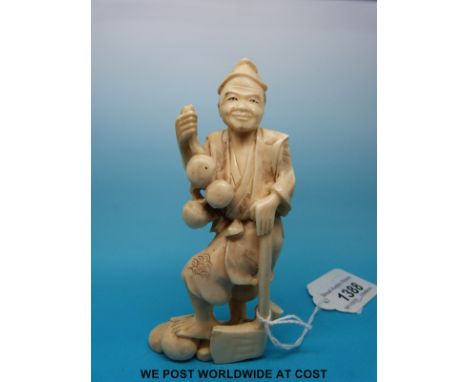 A Japanese Meiji period signed carved okimono of a fruit or gourd gatherer with an axe (12cm tall)
