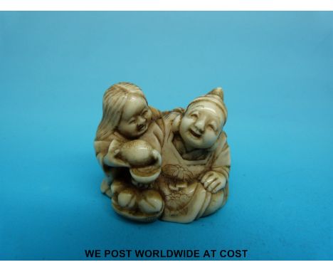 A Japanese Meiji period signed carved ivory netsuke of two laughing figures pouring sake from a gourd (3.5cm tall)