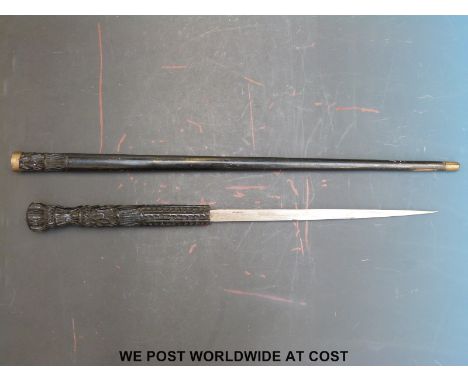 A swordstick with heavily carved wooden handle, brass banding and a 32cm tapering blade (overall length 87cm)