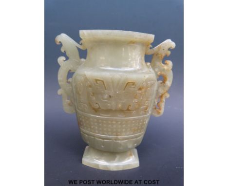 A Chinese archaistic mottled jade vase, the vase of slender form with carved taotie masks and stylized dragon handles, 18thC 