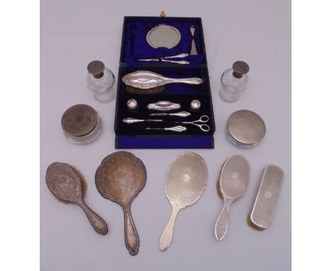 A quantity of hallmarked silver to include dressing table bottles, a hand mirror, hair and clothes brushes and a cased travel