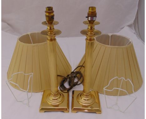 A pair of gilt metal columnular table lamp stands on raised square bases to include shades, 45cm (h)