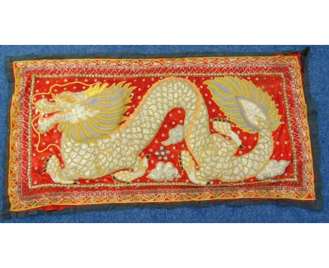 A rectangular Burmese embroided stump work panel of a dragon, 89 x 170cm