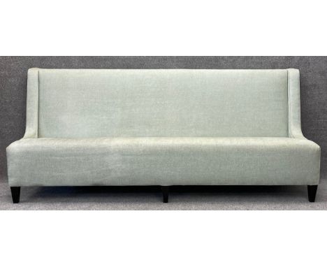 A large contemporary sofa/settle in green patterned upholstery, on stained oak legs. H.110 W.251 D.51cm
