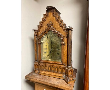 A late nineteenth century Gothic revival oak bracket clock, with Westminster eight bell chime, brass dial standing on pedesta