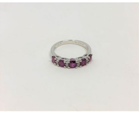 A 14ct white gold ruby and diamond ring, featuring five round cut rubies (1.06ct), claw set with eight round brilliant cut di