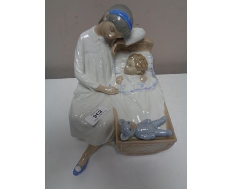 A large Nao figure depicting a child seated on a cushion by a baby in crib 