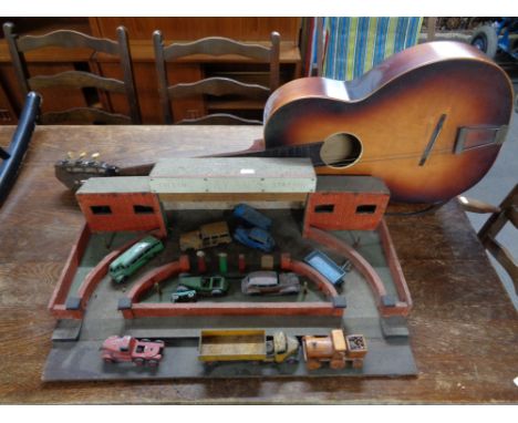 A vintage child's toy filling station, die cast vehicles including Dinky, Super Toys truck etc and an acoustic guitar 