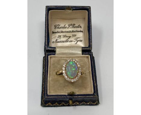 An 18ct gold opal and diamond cluster ring, size R. CONDITION REPORT: Opal measurement 8.6 mm x 12.4 mm approx. It appears to