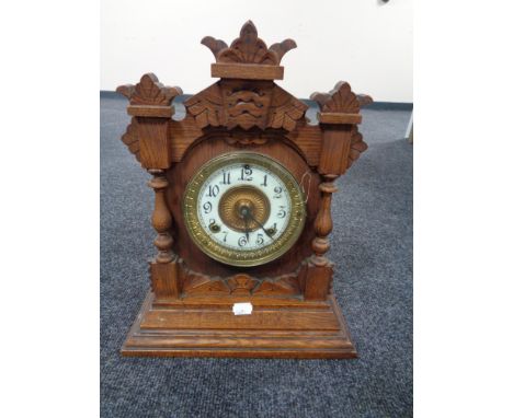 An Edwardian oak mantel clock with enamel dial by the Ansonia clock company 