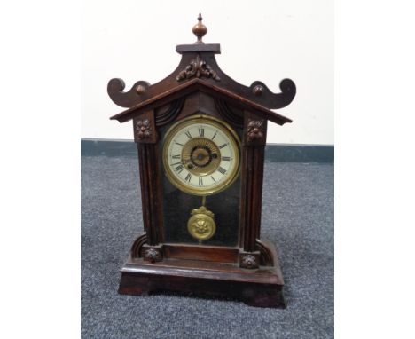 An early twentieth century stained beech alarm clock with pendulum 