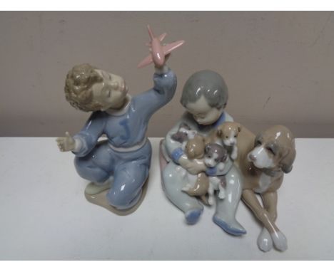 A Lladro figure - Child holding dogs together with a Nao figure of a child with aeroplane (2)