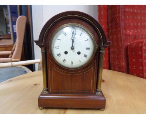 An Edwardian inlaid mahogany bracket clock with brass pillar supports 