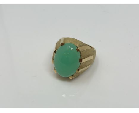 A continental yellow gold ring, the textured shank set with a cabochon apple green jade stone, size N, 10.8g.