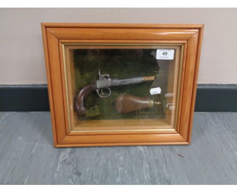 A montage in glazed box frame : Ornamental flintlock pistol with brass and copper powder flask, overall dimensions 28 cm x 33