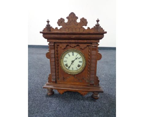 An Edwardian oak mantel clock with enamel dial by the Ansonia clock company 