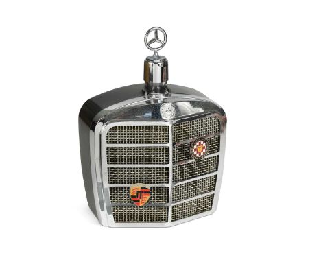 A mid-century motoring themed decanter, in the form of a chrome Mercedes radiator grille with a swivelling three-pointed star