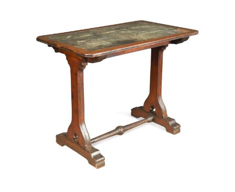 A Puginesque oak library table, with leather inset canted rectangular top, on shaped and pierced end supports and sleigh feet