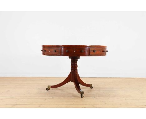 A George III mahogany rent table,c.1800, the revolving circular top above an arrangement of alternating drawers and cupboards