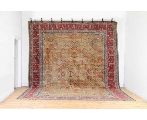 A Persian wool carpet,20th century, the yellow field with repeating geometric foliate detail within a triple border,426 x 353