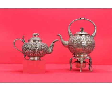 An Indian silver spirit kettle,late 19th early 20th century, the hinged cover with a bodhisattva final above a chased and emb