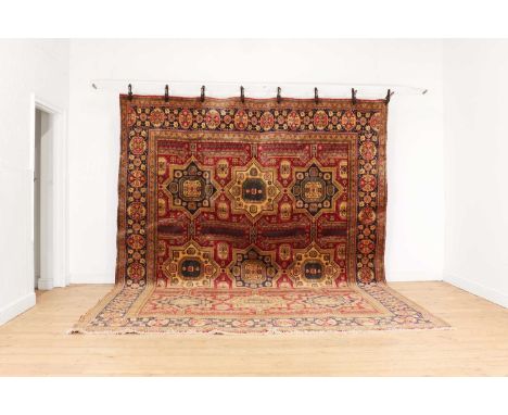 A large Azerbaijan carpet,with nine medallions to a red field and blue border,380 x 290cmCondition ReportGood condition, with