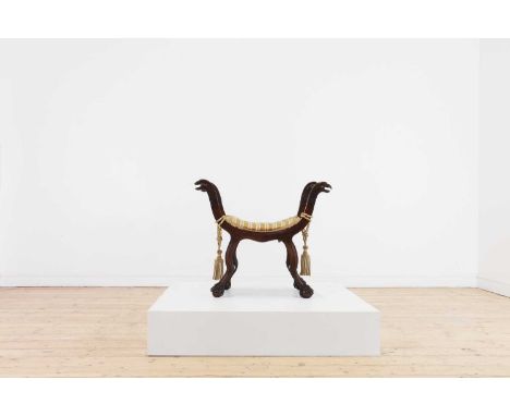 A Renaissance-style carved walnut stool,late 19th century, Italian, of 'X' shape with eagle head finials above a padded seat,