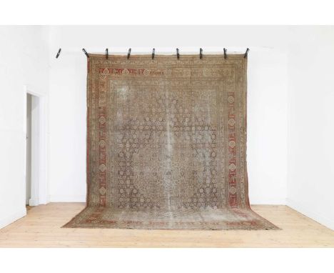 A Persian wool carpet,late 19th century, Iranian, Tabriz, the field with a central medallion and Herati motifs, within floral