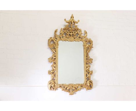 A Chinese Chippendale-style giltwood mirror,20th century, the pierced scrolling frame surmounted with a pagoda and a figure, 