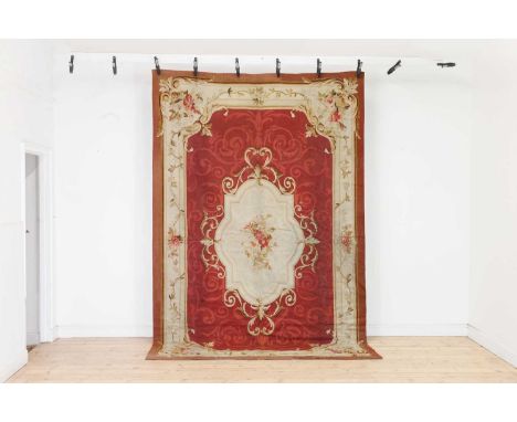 An Aubusson wool rug,19th century, French, centred with a shaped medallion decorated with a bouquet of flowers, within floral