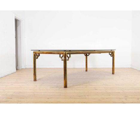 A chinoiserie brass dining table,of recent manufacture, with a glass top above a Chinese coromandel lacquer panel, raised on 