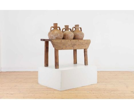 A pine pot stand containing three clay amphora vases,20th century, each twin-handled pot inset into the base,108cm wide39cm d