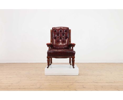 A Victorian walnut library armchair,with a buttoned red leather back and seat, raised on tapering square supports, terminatin