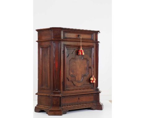 A walnut credenza,18th century and later, Italian, the shaped top above a quatrefoil panelled door, on a plinth base, 79cm wi