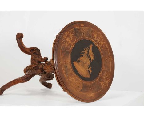 A walnut and inlaid occasional table, c.1900, Swiss, the circular top centred with mountain goats within foliate scrolls, rai