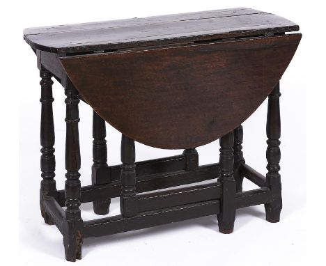 A oak gateleg table, late 17th c, the plank top with pair of folding D-shaped leaves on ring turned legs joined by moulded st