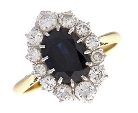 A sapphire and diamond cluster ring,&nbsp;the larger dark blue sapphire within a surround of 12 round brilliant cut diamonds,