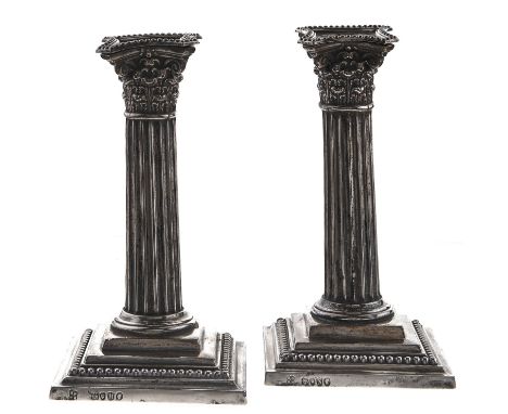 A pair of Victorian silver dwarf columnar candlesticks, on stepped square foot, nozzles, 15.5cm h, London 1887 and 1888, load