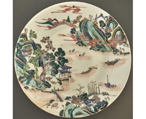 A Chinese famille verte dish, Qing dynasty, Kangxi mark, 19th c, painted with a river scene, mountains and clouds, 37.5cm dia