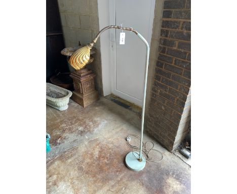 A vintage painted metal floor lamp with brass shade