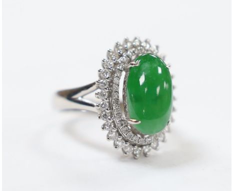 A modern 18k white metal, cabochon jade and two row diamond chip set oval cluster ring size L, gross weight 6.4 grams.