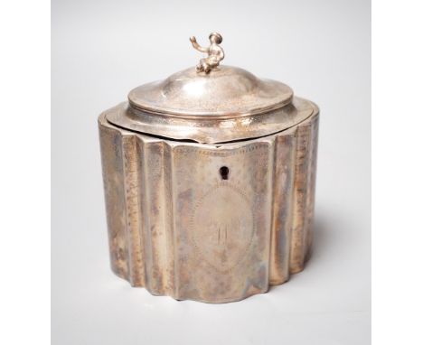 A George III engraved silver shaped oval tea caddy, the finial modelled as a seated oriental figure, Robert Hennell I, London